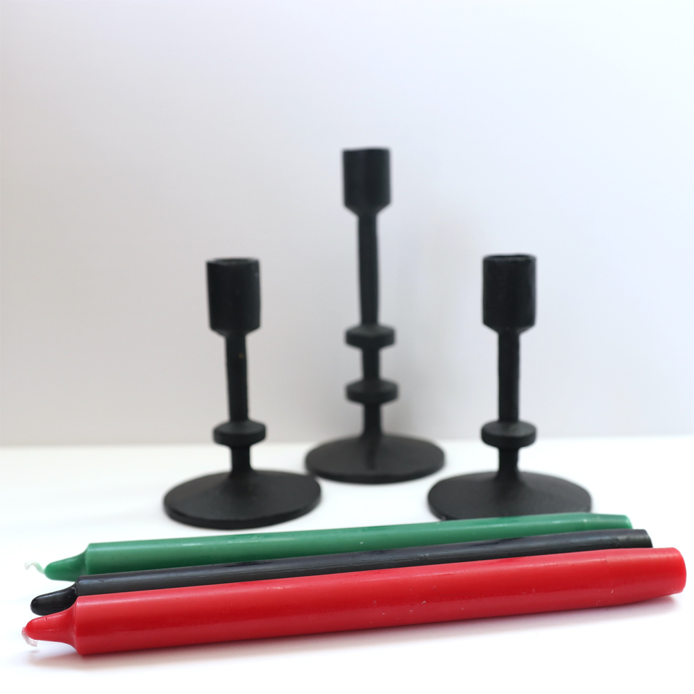 Candle holders with red, black, and green candles in front. 