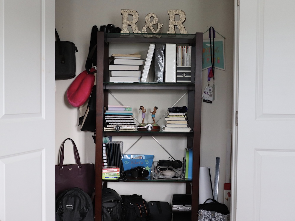 A closet with white walls and a dark bookcase. A closet with white walls and a dark bookcase.