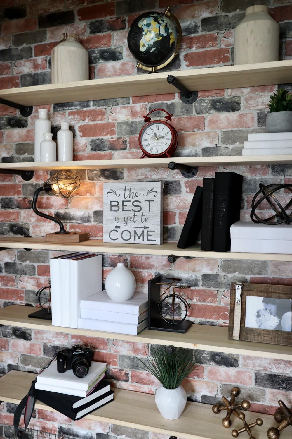 A closet with decorated open shelves and a brick peel-and-stick wallpaper back wall. A closet with decorated open shelves and a brick peel-and-stick wallpaper back wall.
