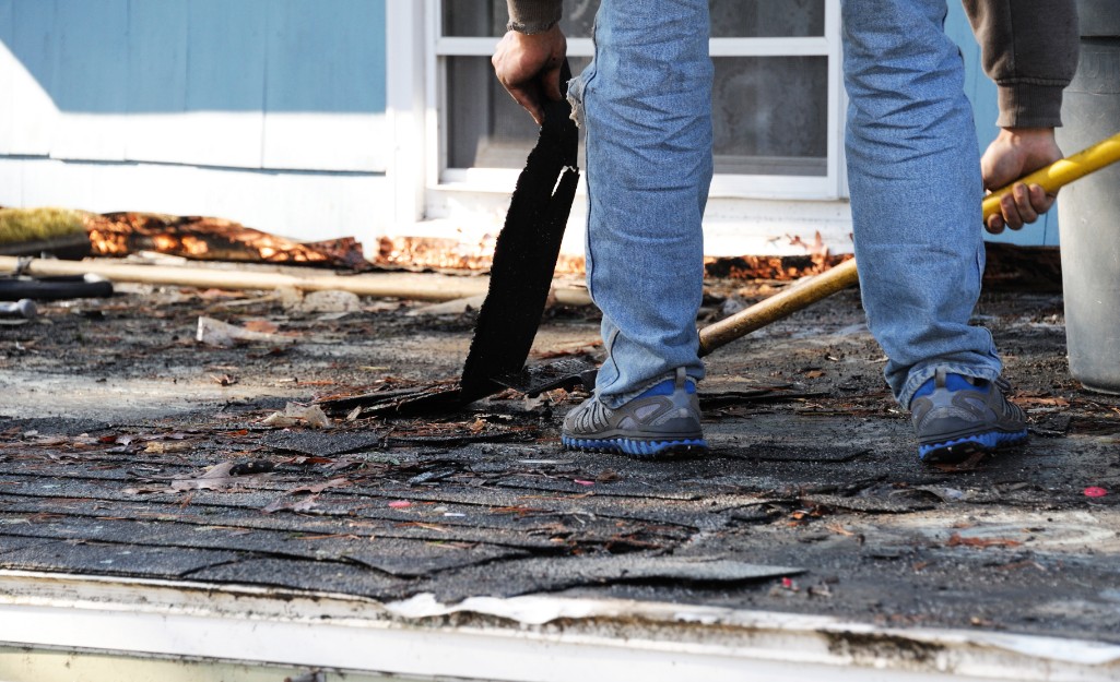 A Pro removes old shingles from a low-slope roof.