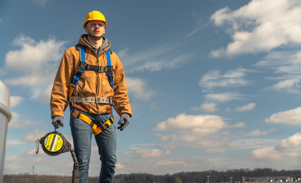 A worker wears a safety harness for fall protection.