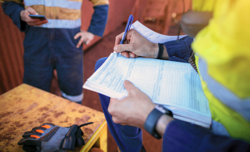 A person uses a safety checklist during an inspection.