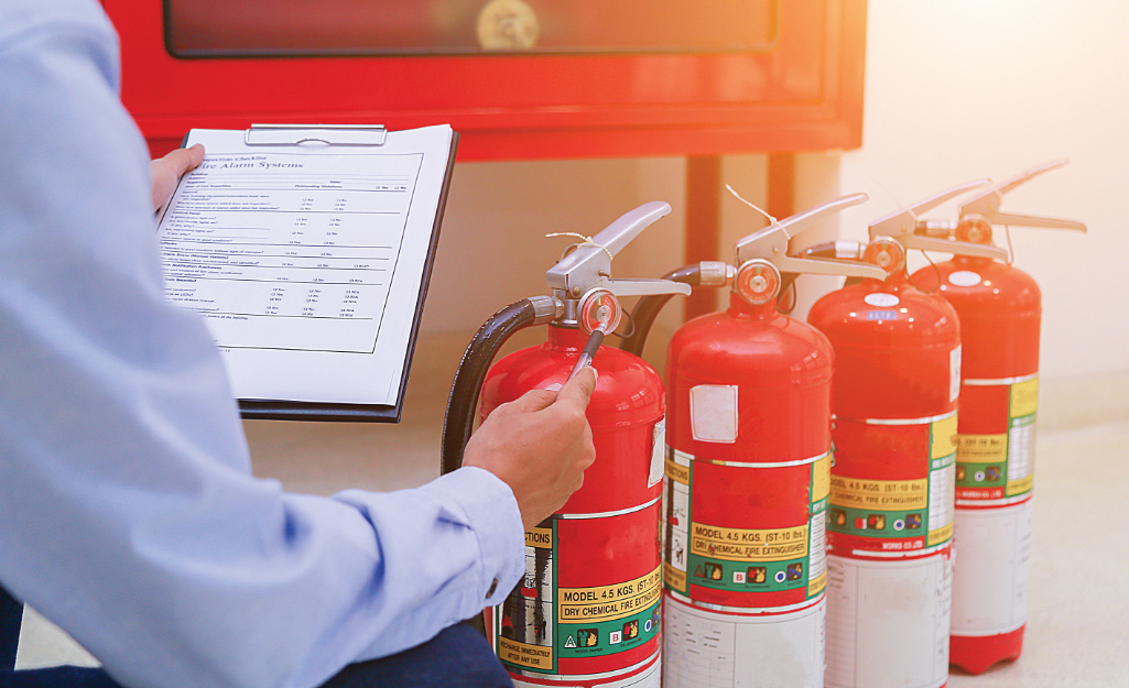 A person inspects fire extinguishers.