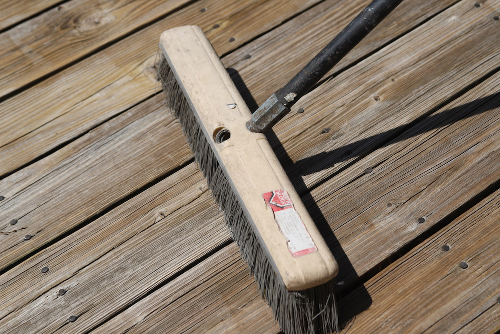 A deck is brushed off with a large broom. A deck is brushed off with a large broom.