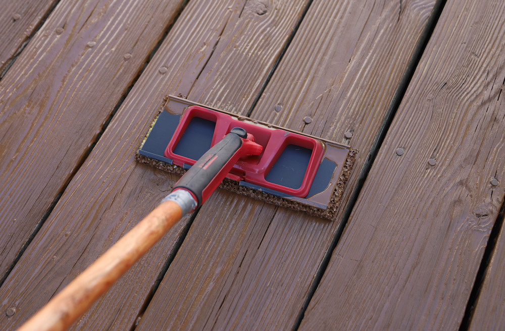 A deck stain applicator applies stain to a deck floor. A deck stain applicator applies stain to a deck floor.