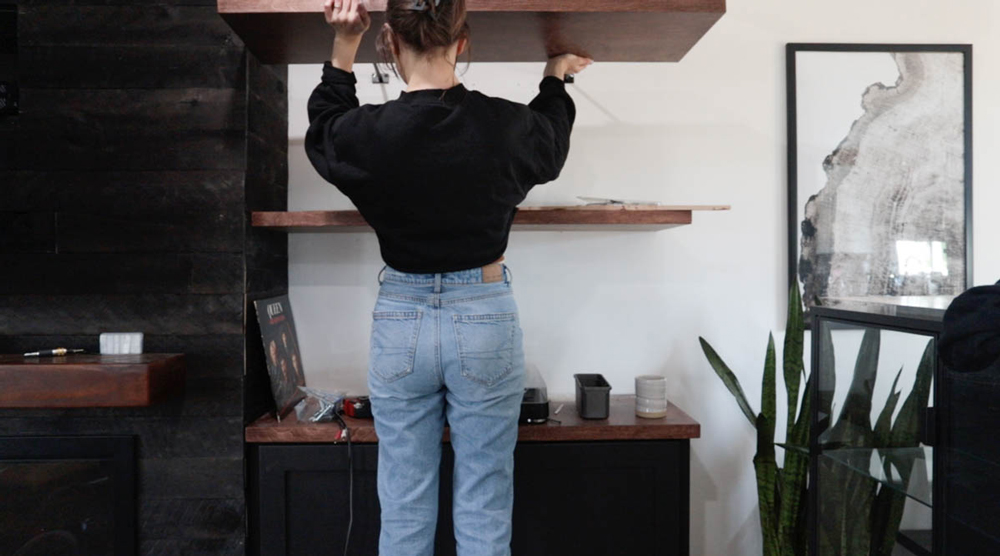 A person using a hidden floating shelf hardware to input a shelf.