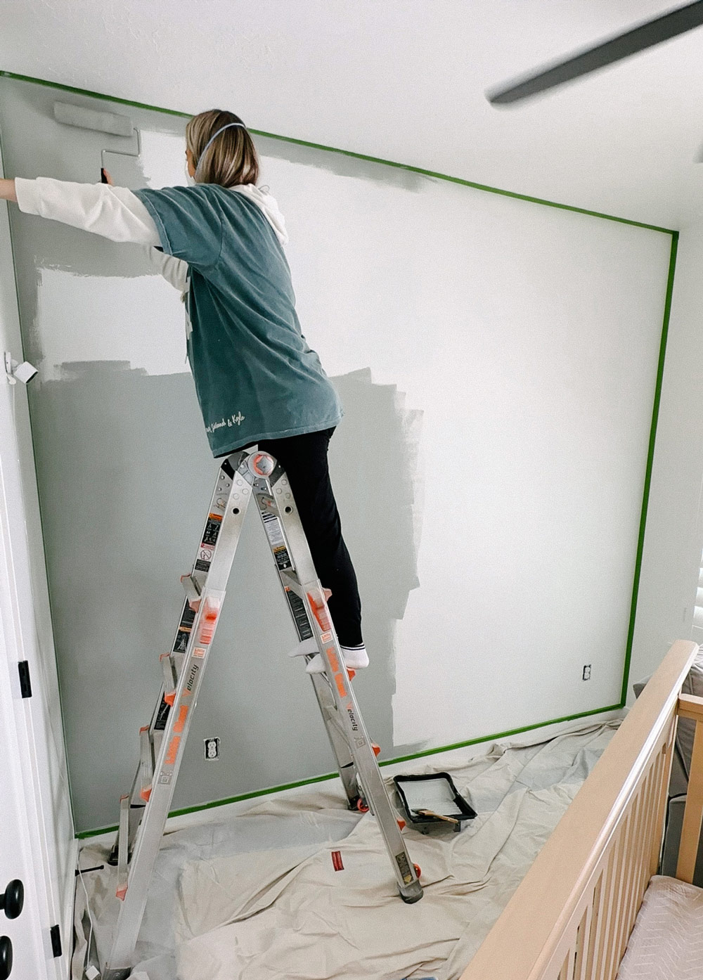 A person painting an accent wall.