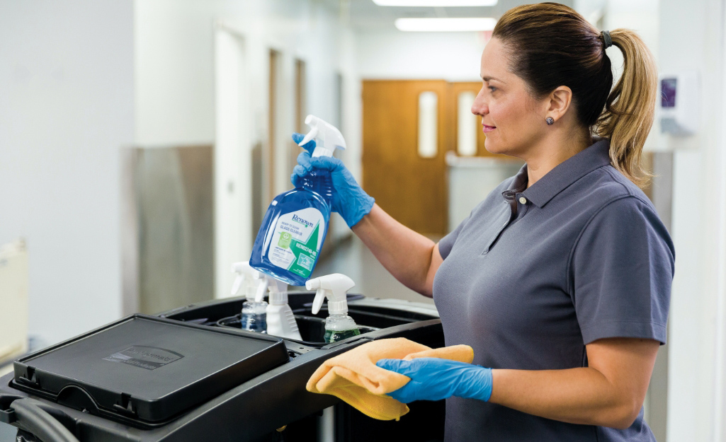A member of a janitorial staff prepares cleaning supplies.