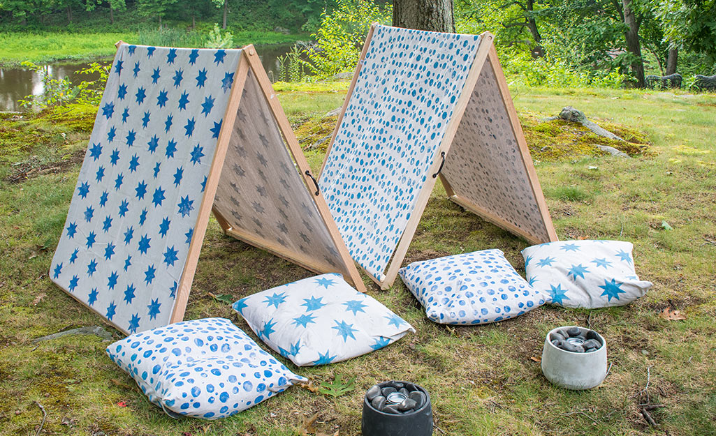 Two completed canvas tents surrounded by DIY pillows.