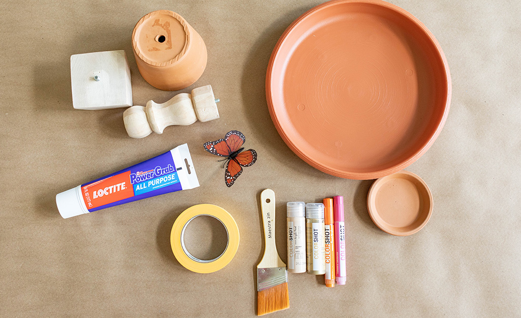 Supplies to build a butterfly feeder sit on kraft paper. Supplies to build a butterfly feeder sit on kraft paper.