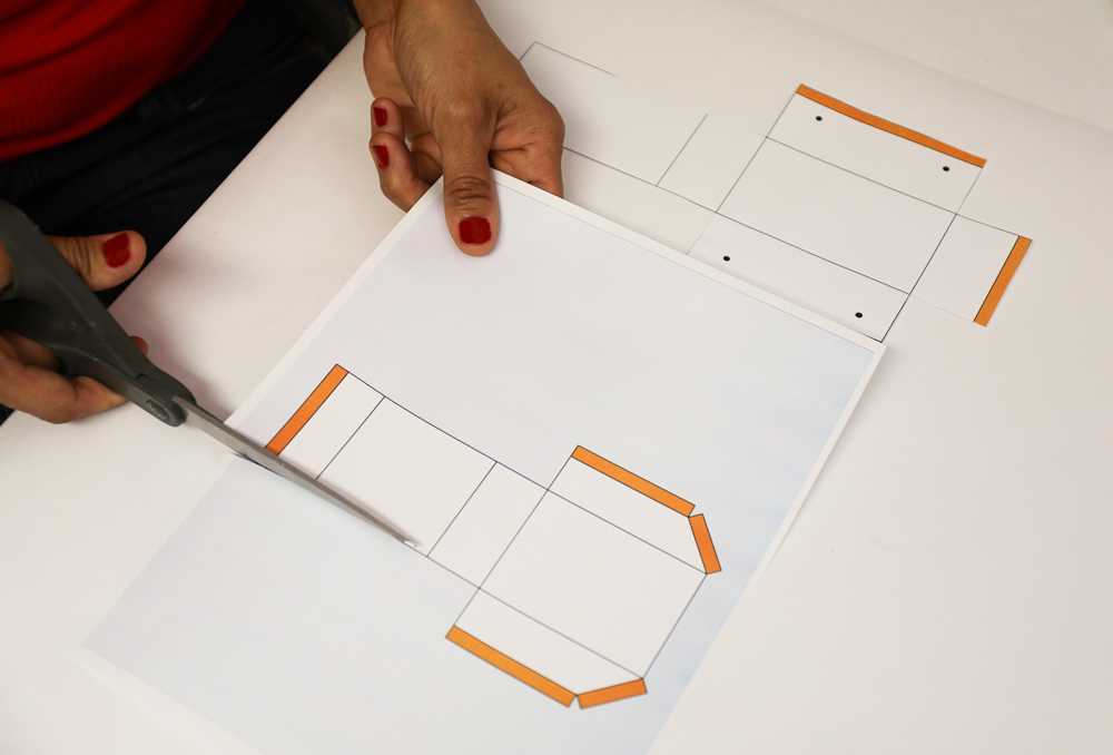 A woman’s hands cutting out a paper template with scissors