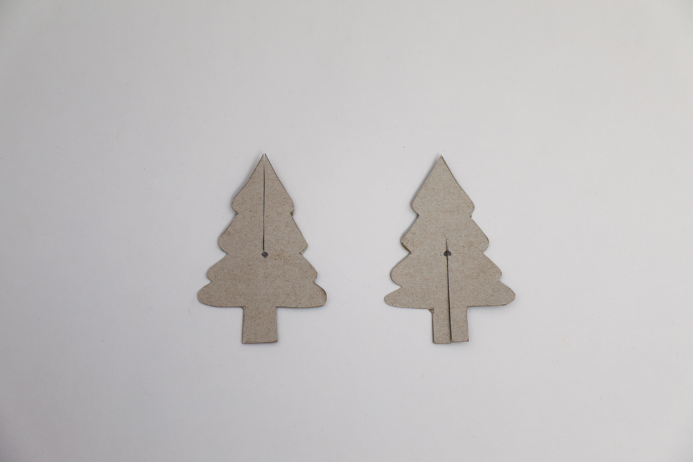 Two pieces of cardboard cut out into tree shapes