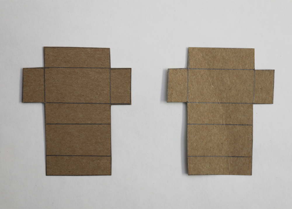 Two outlined pieces of cardboard placed on a white table top 