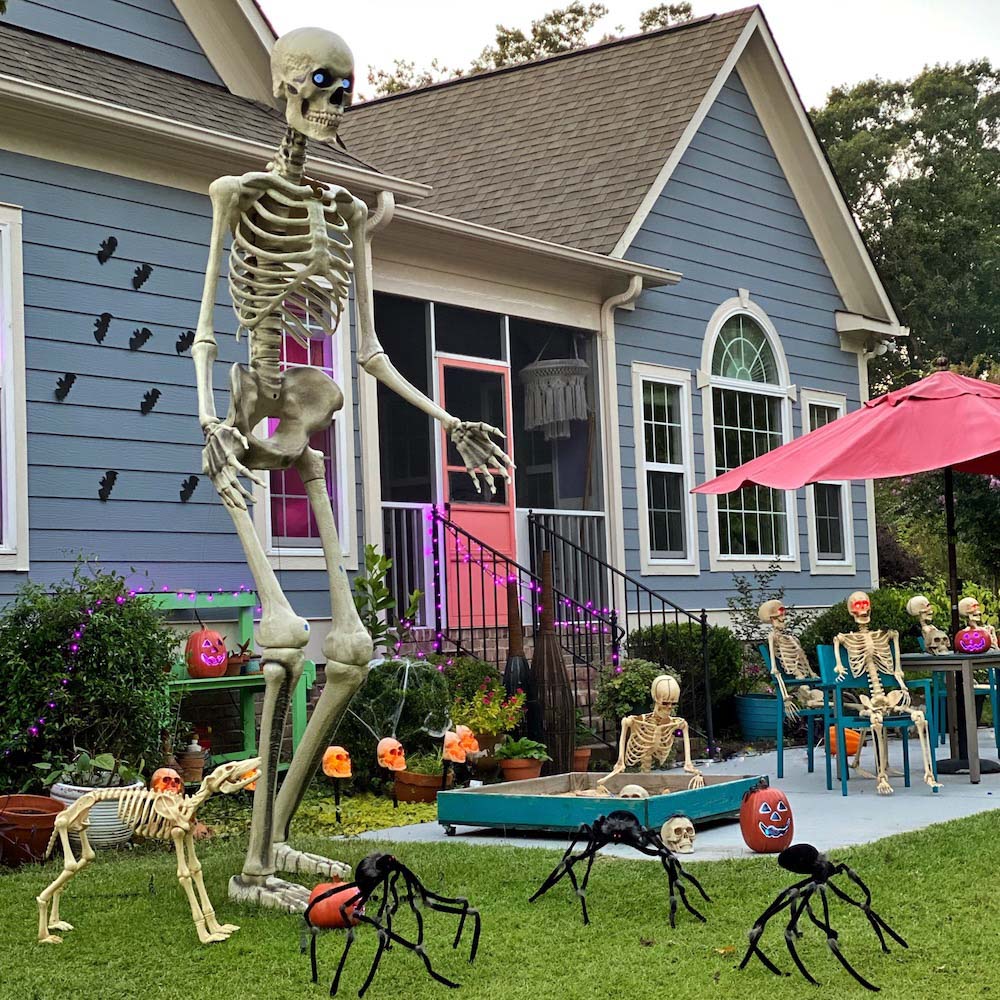 A giant skeleton standing in front of a blue house.