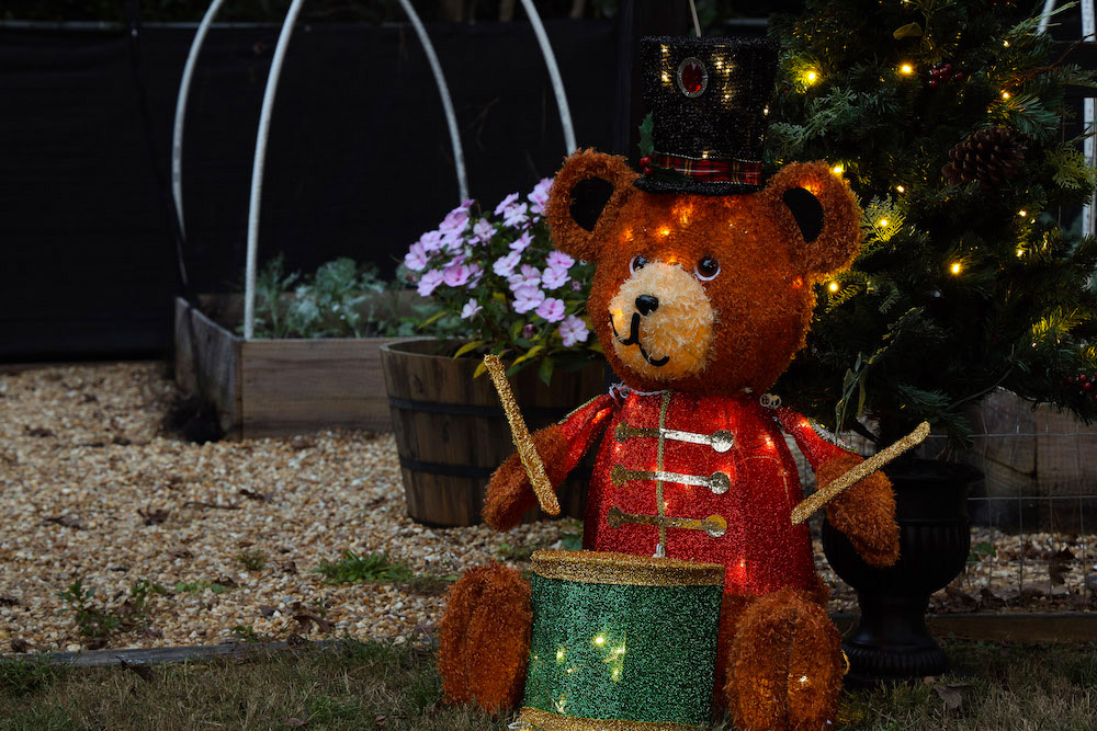 Close up shot of LED teddy bear and pre-lit tree in garden