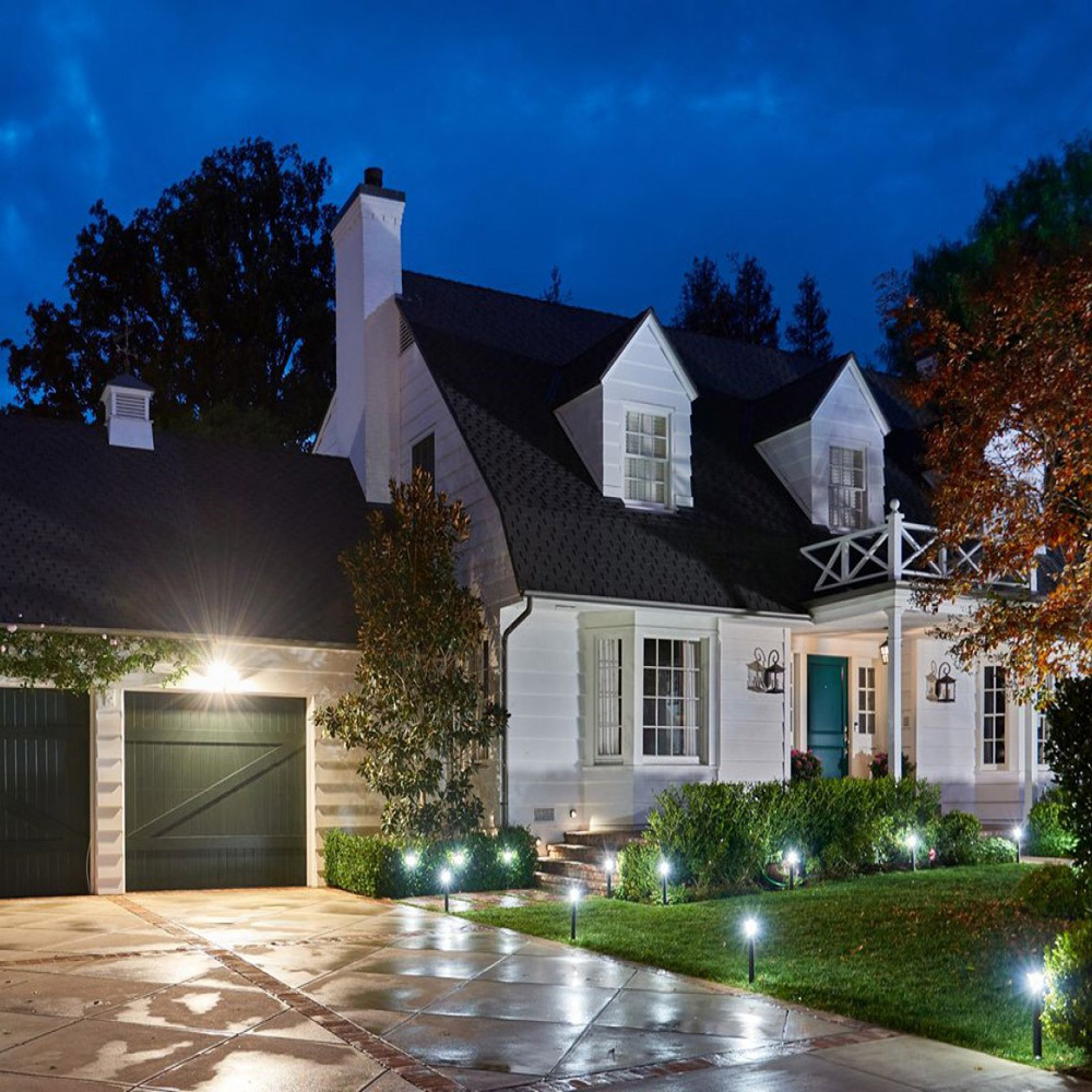 A home with outdoor lighting on at night. A home with outdoor lighting on at night.