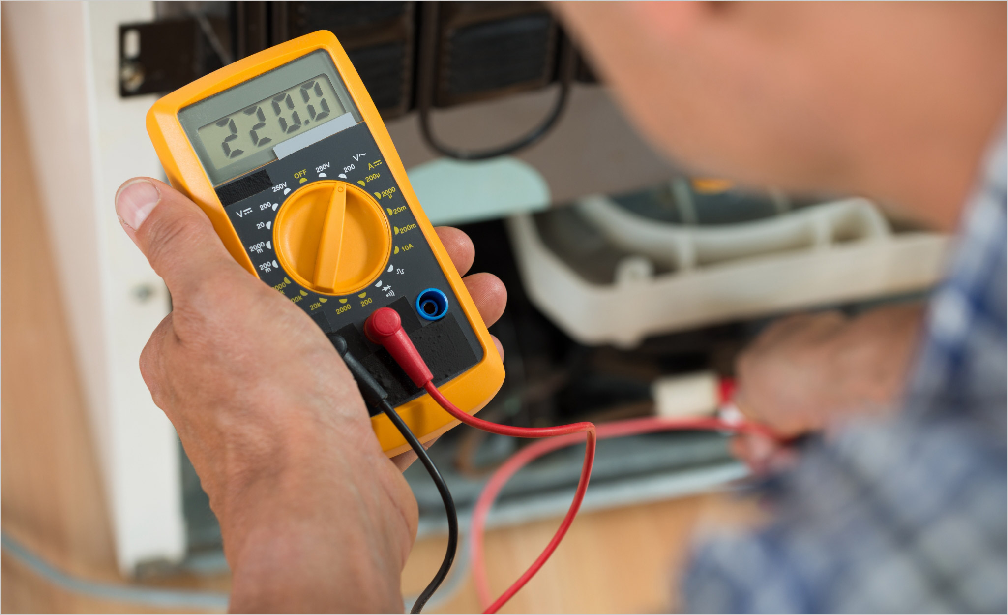 A Pro uses a multimeter to check whether wiring is hot.