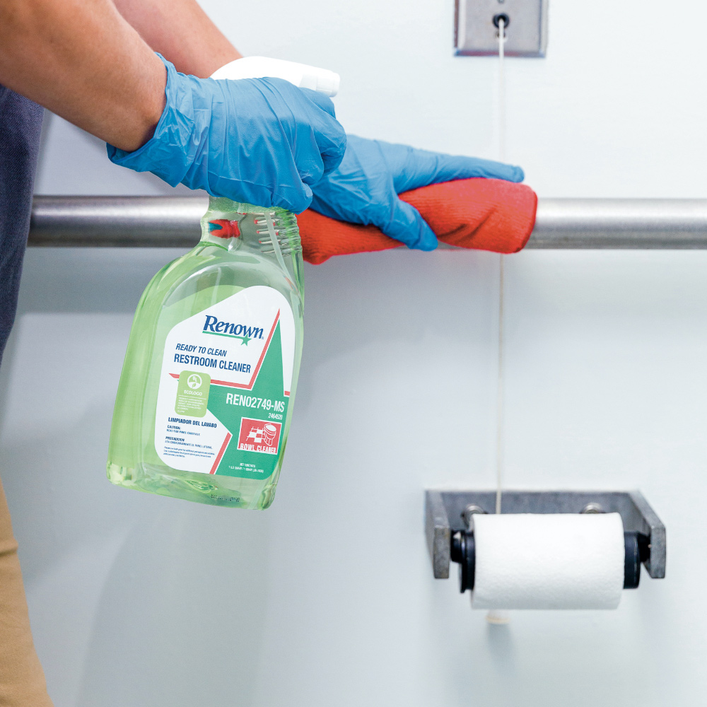 A worker cleans a commercial restroom