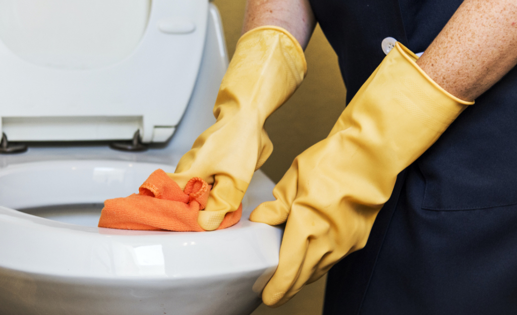 Janitorial staff cleans a toilet