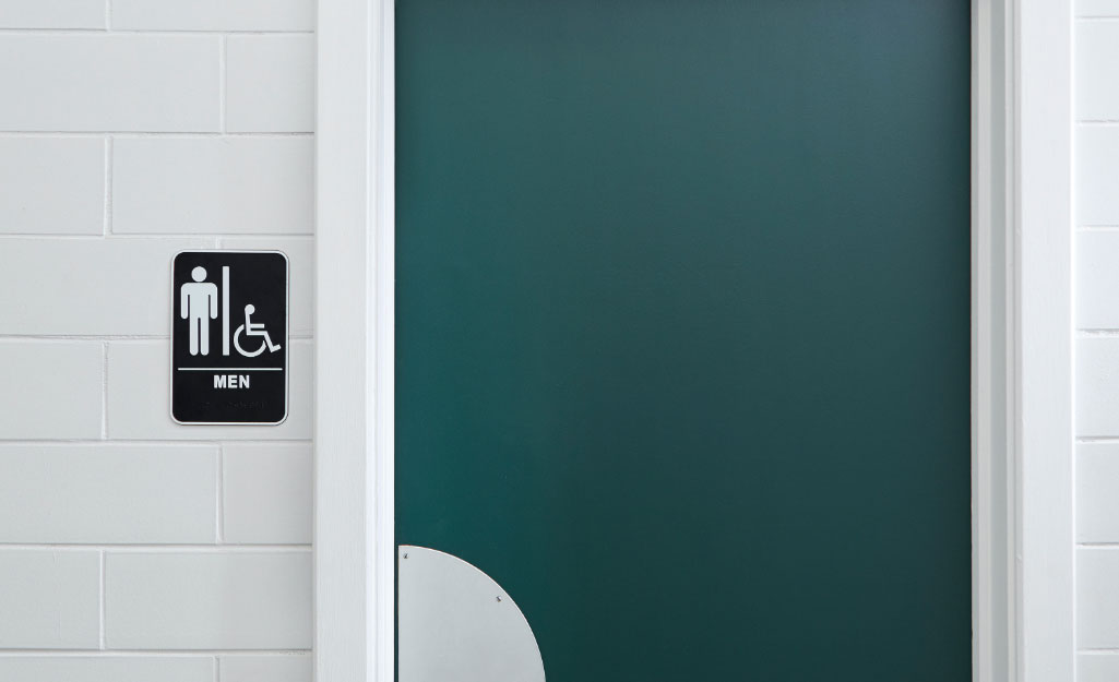 A commercial bathroom door against a white wall