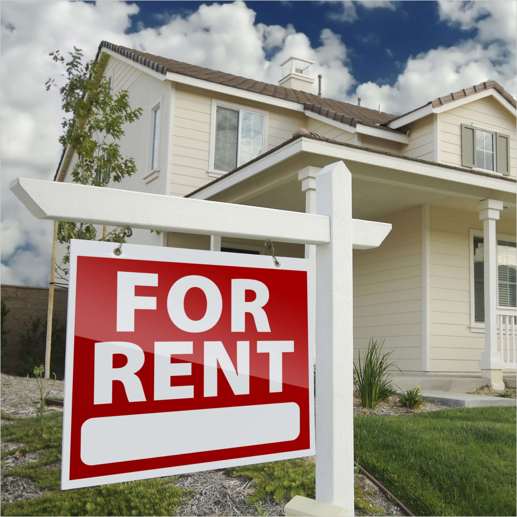 A single-family home with a For Rent sign in front.