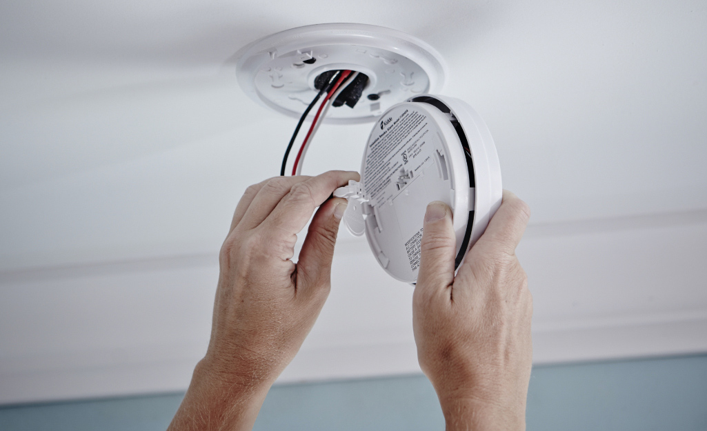 A worker installs a fire alarm A worker installs a fire alarm