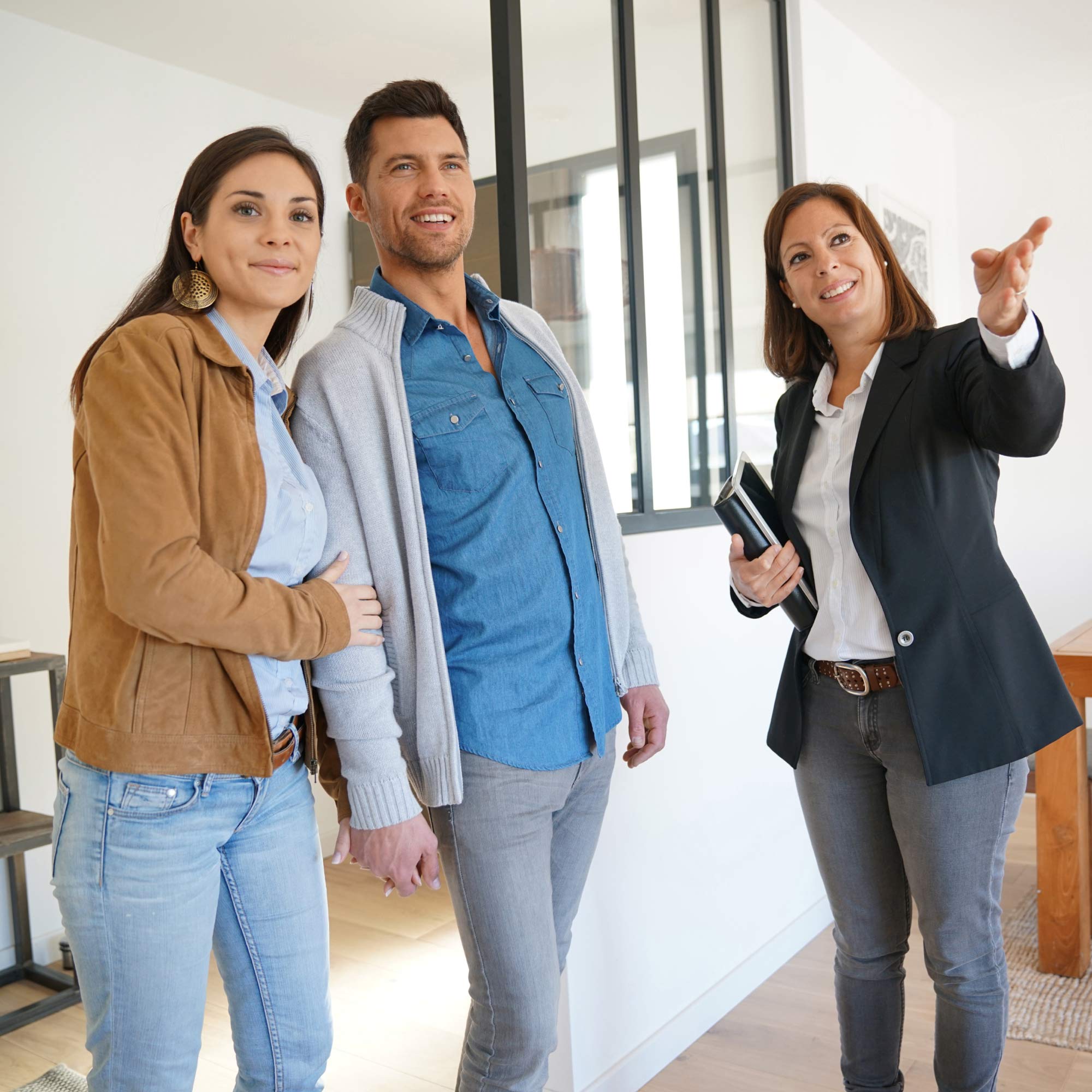 A real estate agent shows a couple a house.