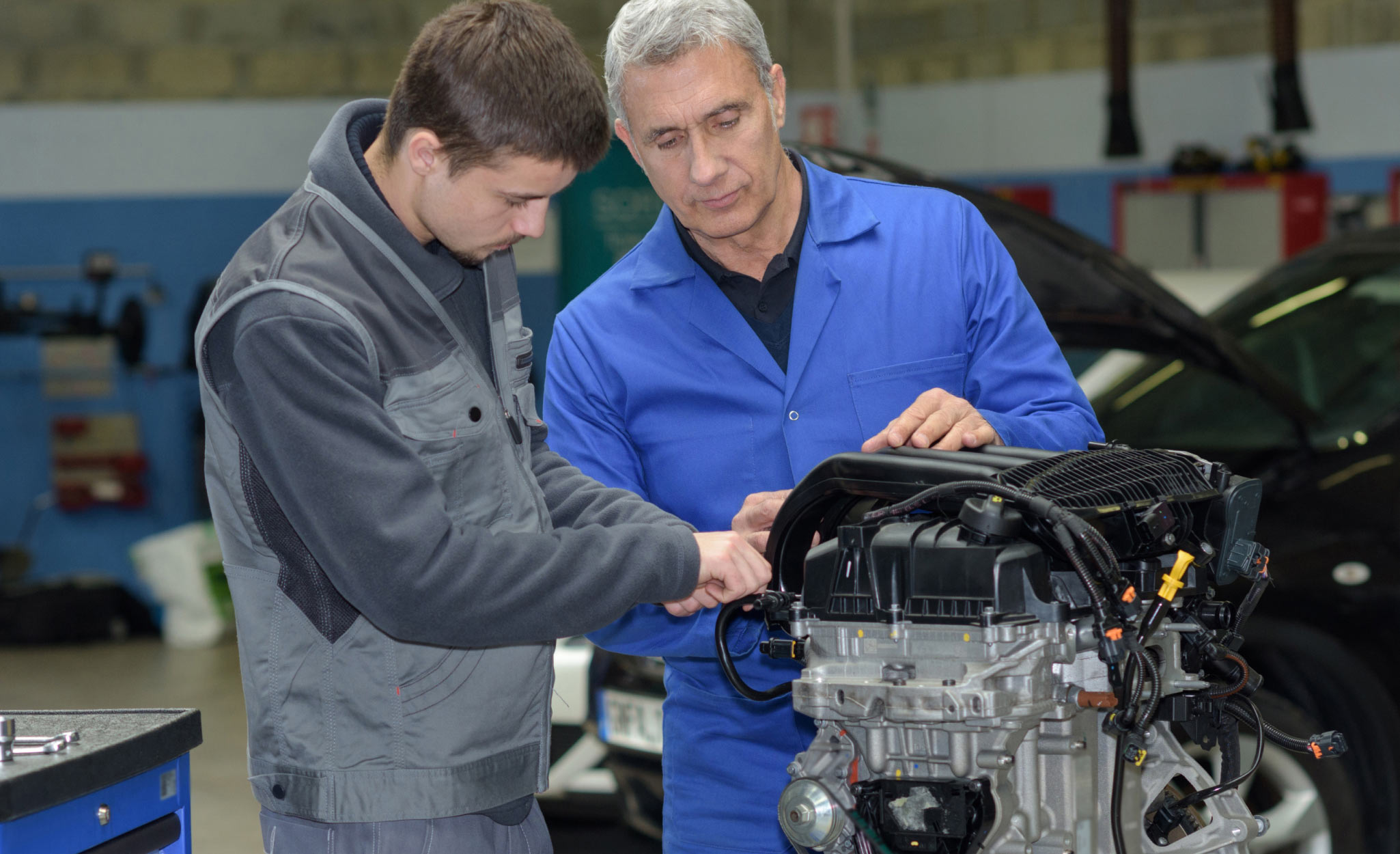 An instructor teaches a student at a trade school. An instructor teaches a student at a trade school.