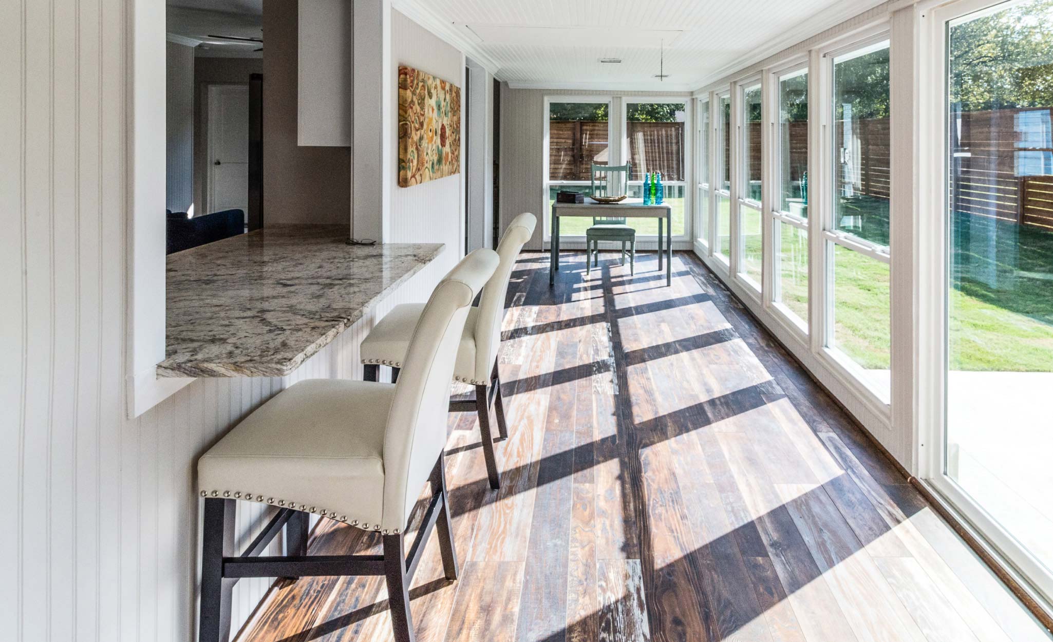 A home uses a stone countertop and maximizes natural light.