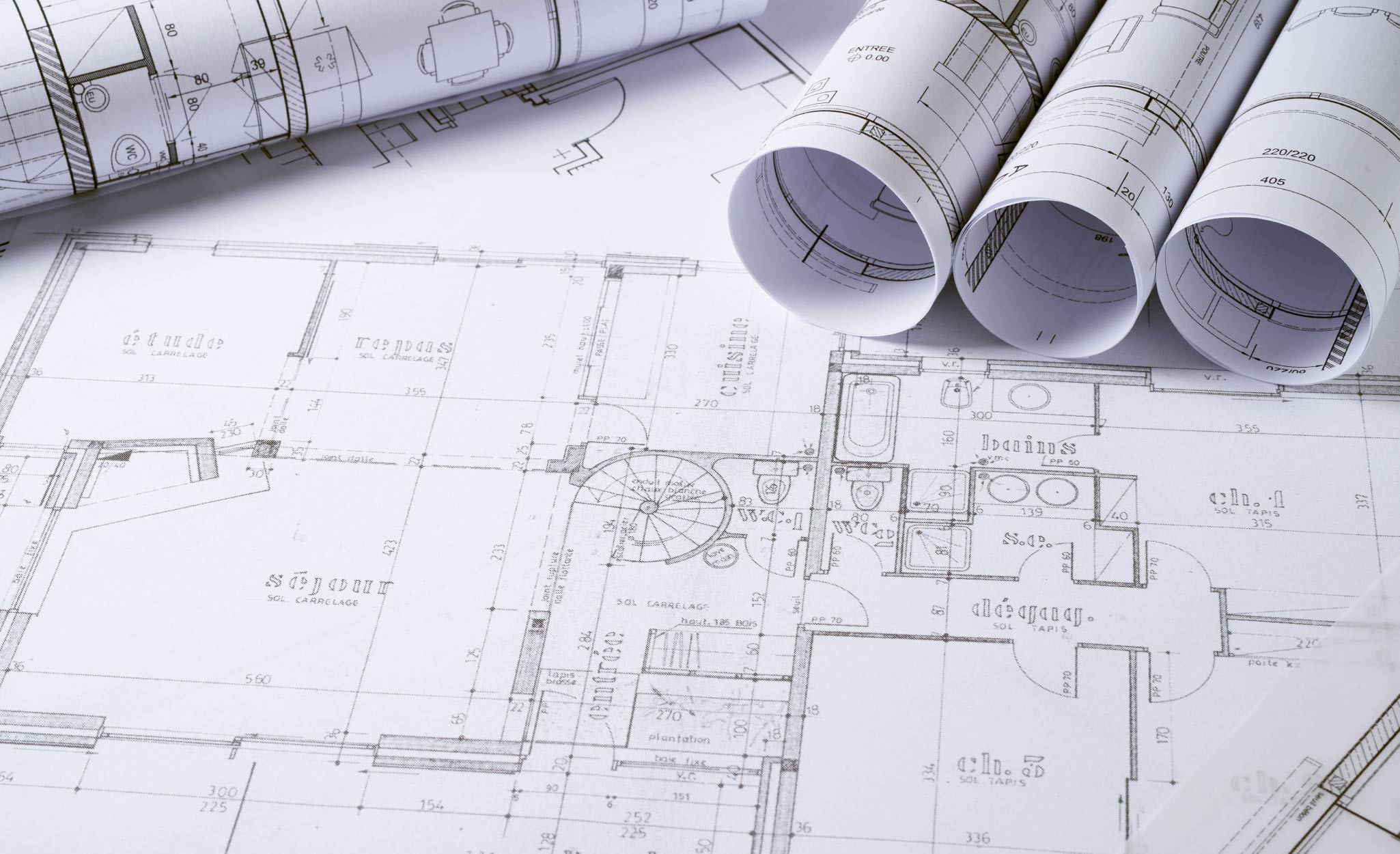 House plans are unrolled on a table.