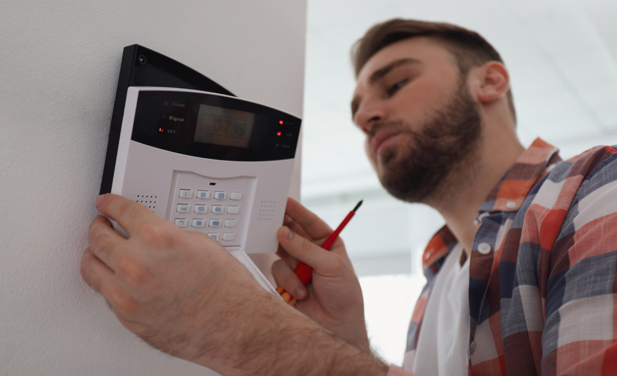 A Pro installs an alarm security system.