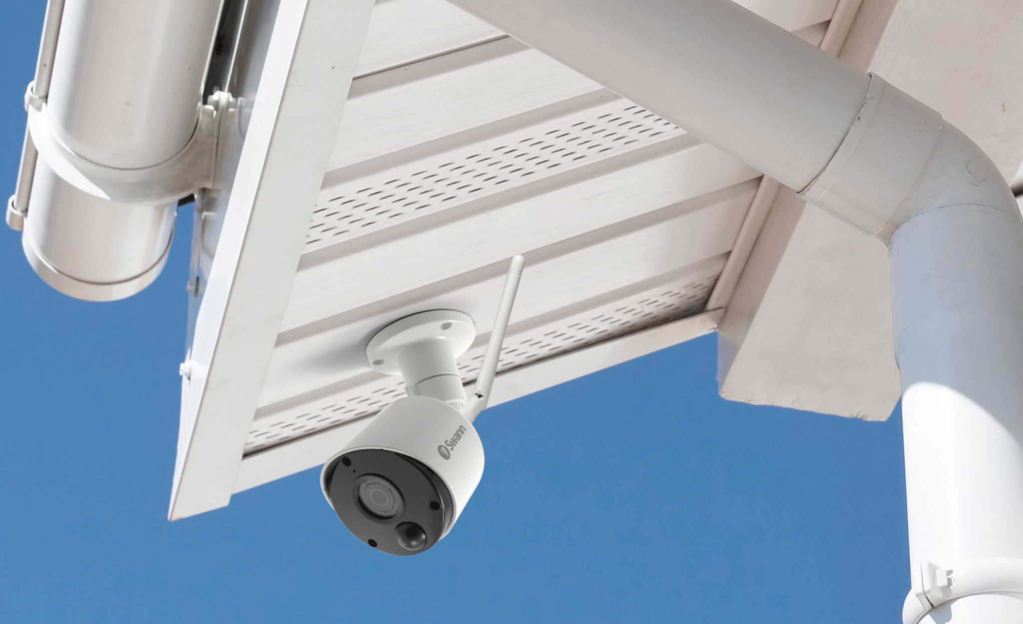 An outdoor security camera installed below a roof.