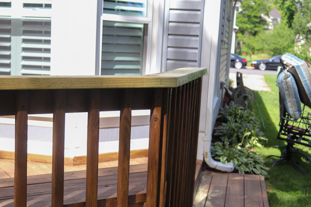 The side of a wooden deck off the back of a home.