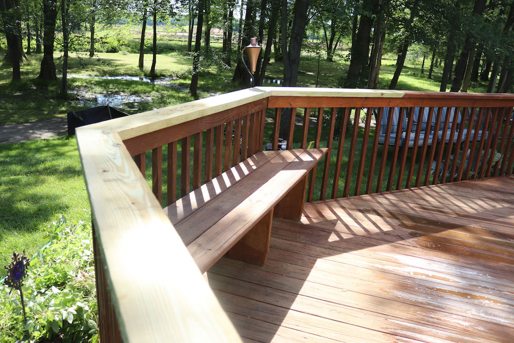 A wooden deck with a built-in bench.
