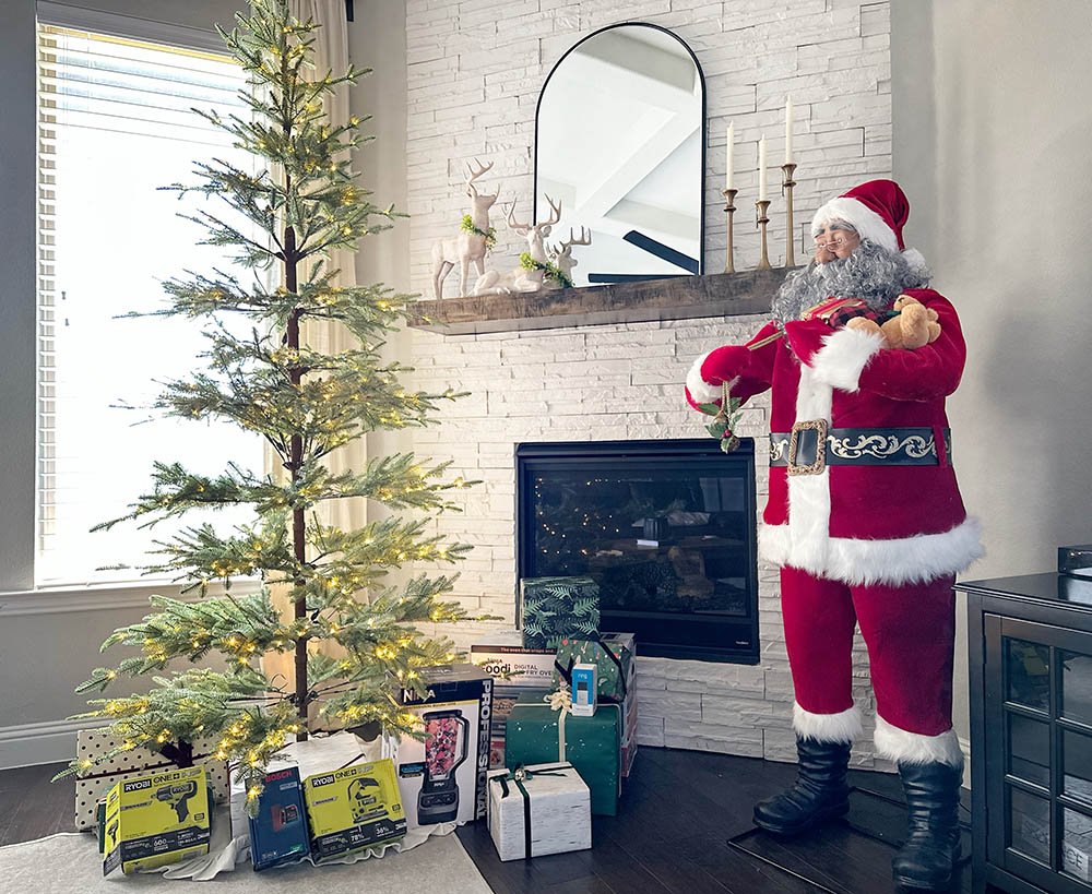 A statue of Santa Claus standing in front of the fireplace.