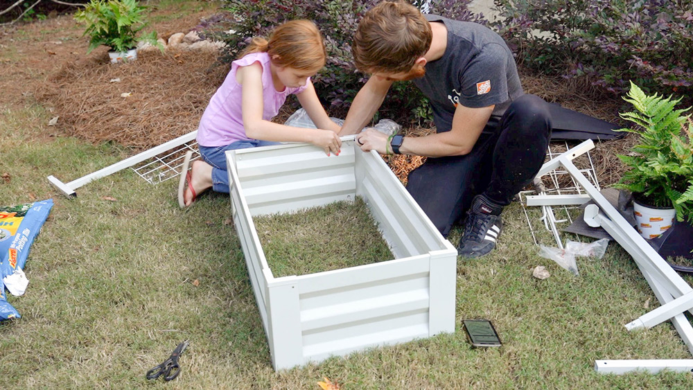 Tyson and Daughter on grass building planter