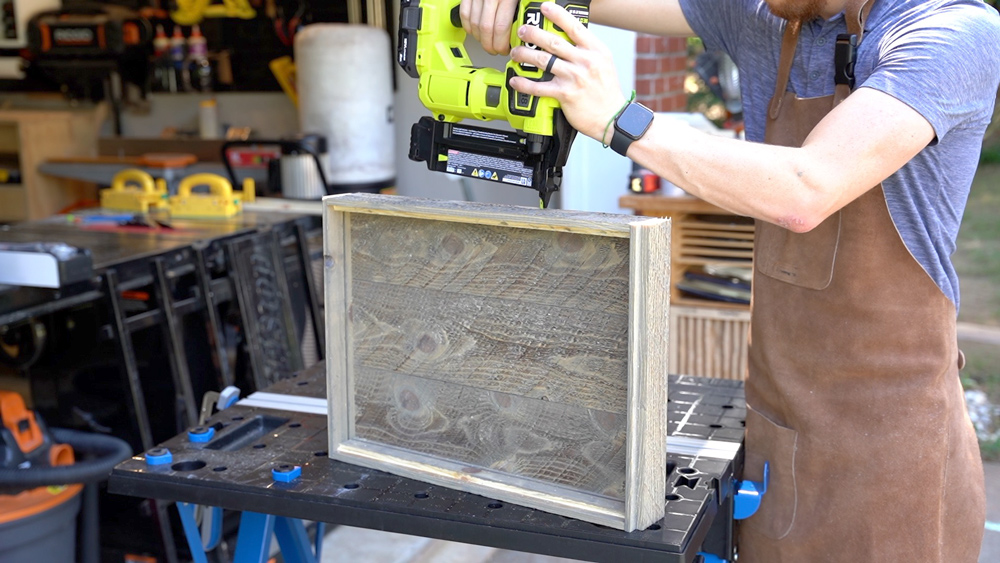 Man using a Brad nailer on a tray. Man using a Brad nailer on a tray.