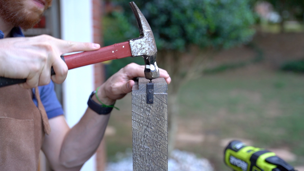 Man nailing wood with a hammer. Man nailing wood with a hammer.