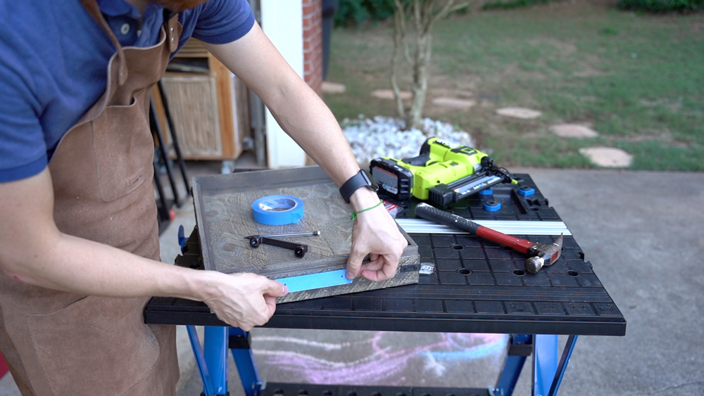 Man placing painters tape on a tray. Man placing painters tape on a tray.
