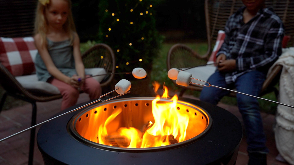 People roasting marshmallows over a fire pit. People roasting marshmallows over a fire pit.