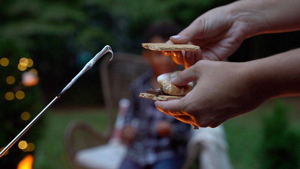 Person holding assembled s’mores. Person holding assembled s’mores.