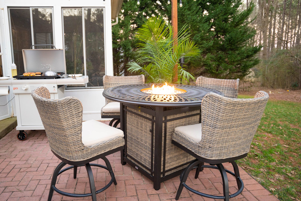 Four wicker chairs around a fire pit table. Four wicker chairs around a fire pit table.