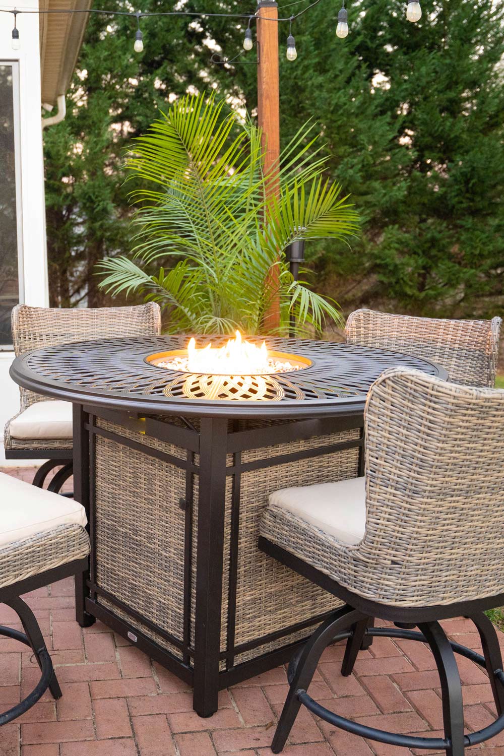 A table firepit with chairs on a brick patio. A table firepit with chairs on a brick patio.