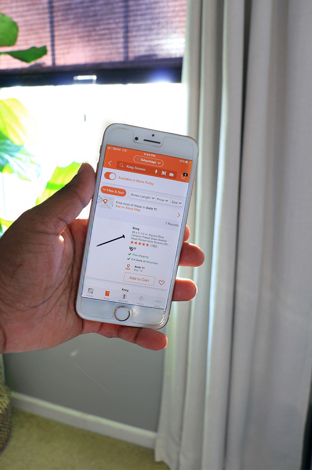Hand holding an iPhone that depicts The Home Depot’s mobile app