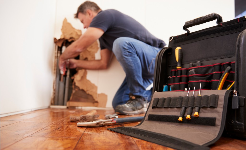 A restoration Pro replaces damaged drywall.