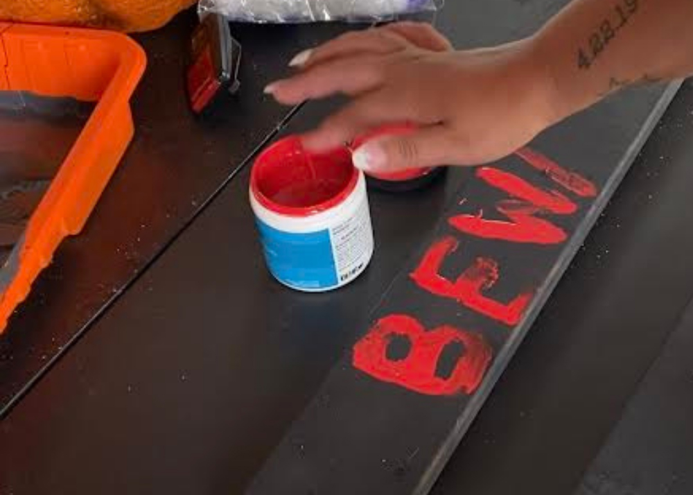 Painting words on board with red paint