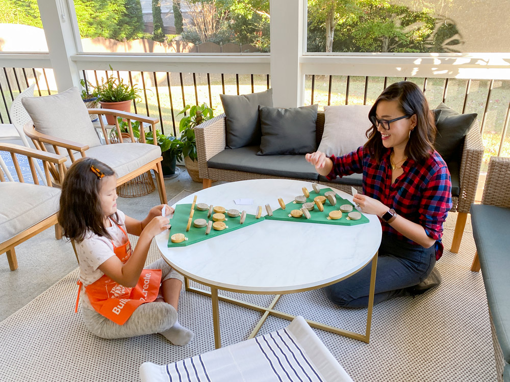 A woman and a child playing a finished board game.