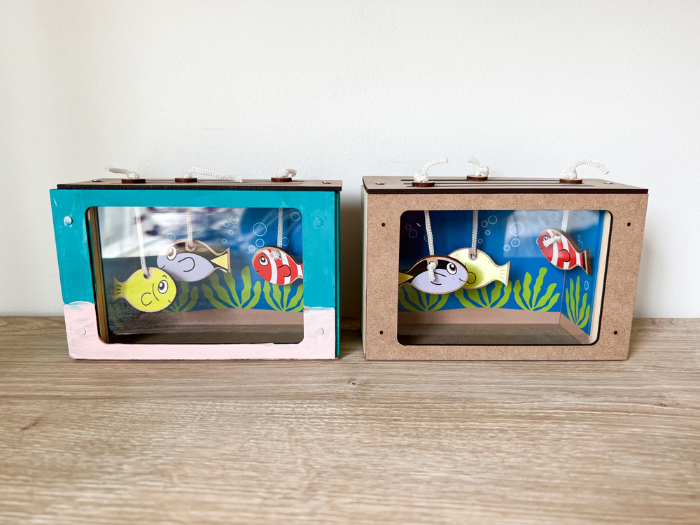 A painted wooden fish tank and an unpainted wooden fish tank.