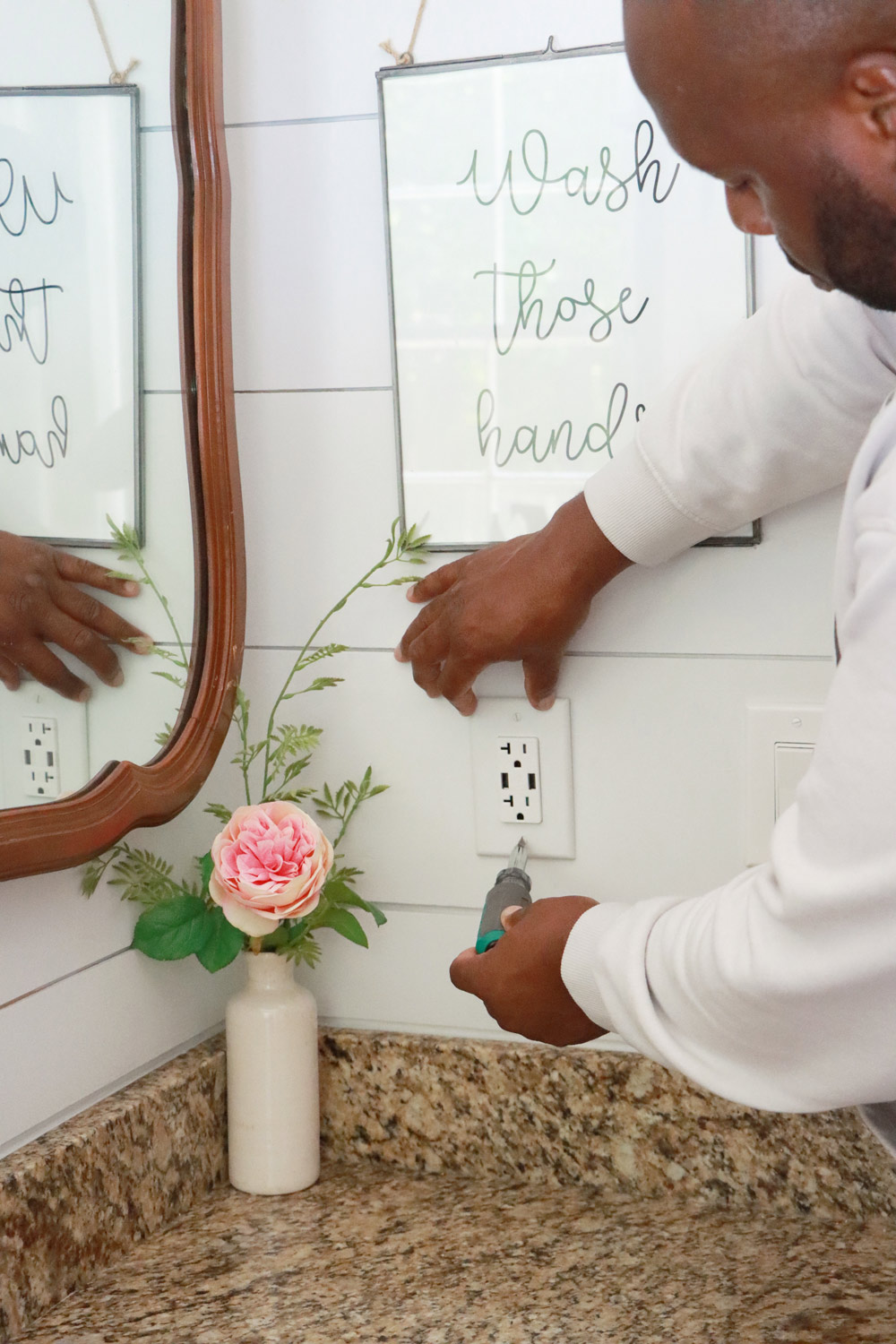 A man screwing in the new outlets in his home.