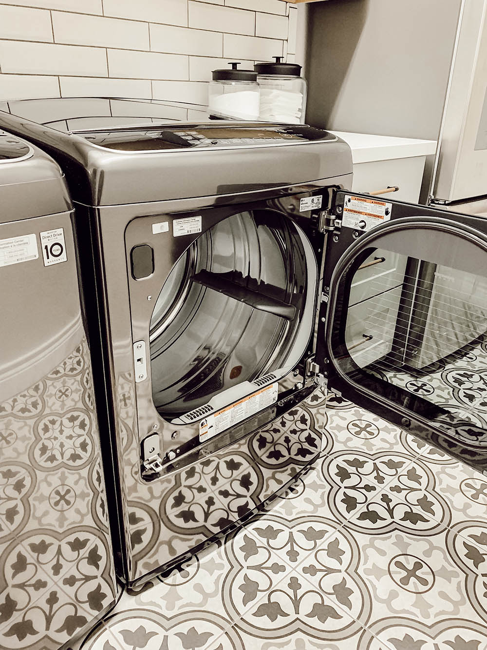 Exterior of the LG Smart Electric Dryer with the door open and mosaic titled flooring.